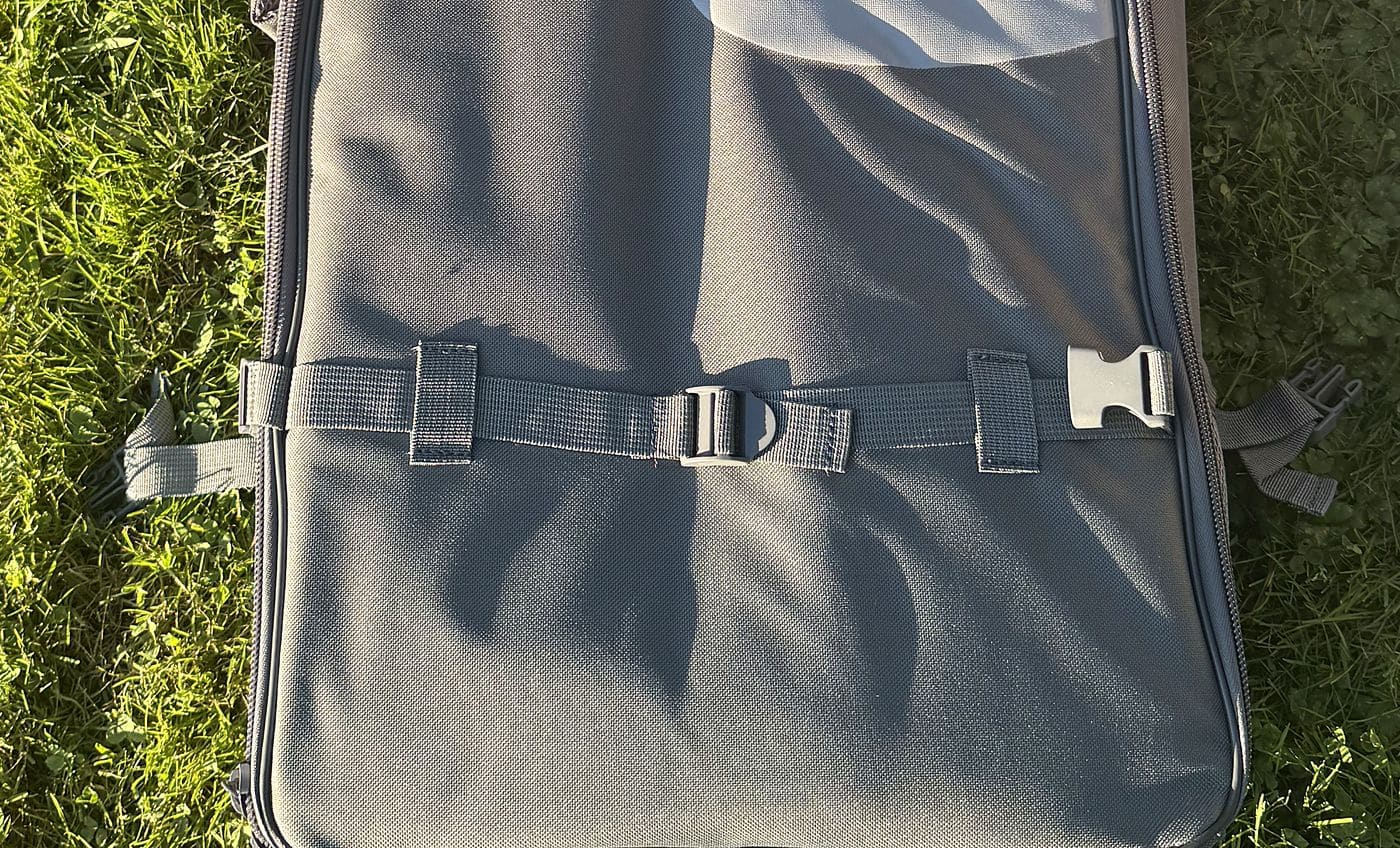 Close-up of the nylon side-release buckles and compression strap across the bottom of the Retrospec backpack