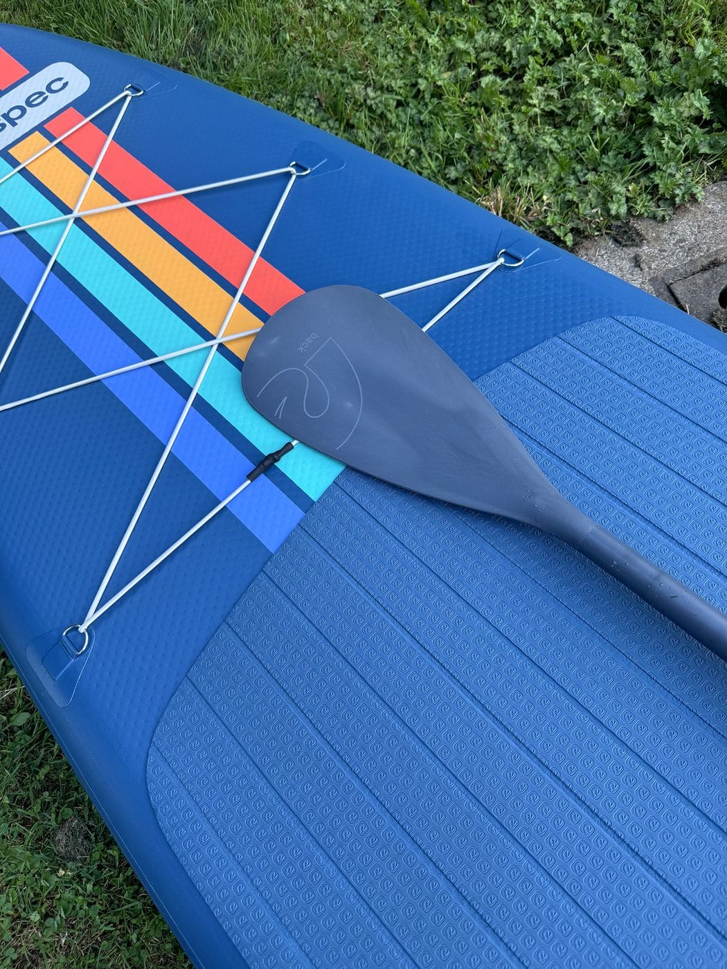 Paddle blade tucked under the six-point nose bungee over the rainbow stripes