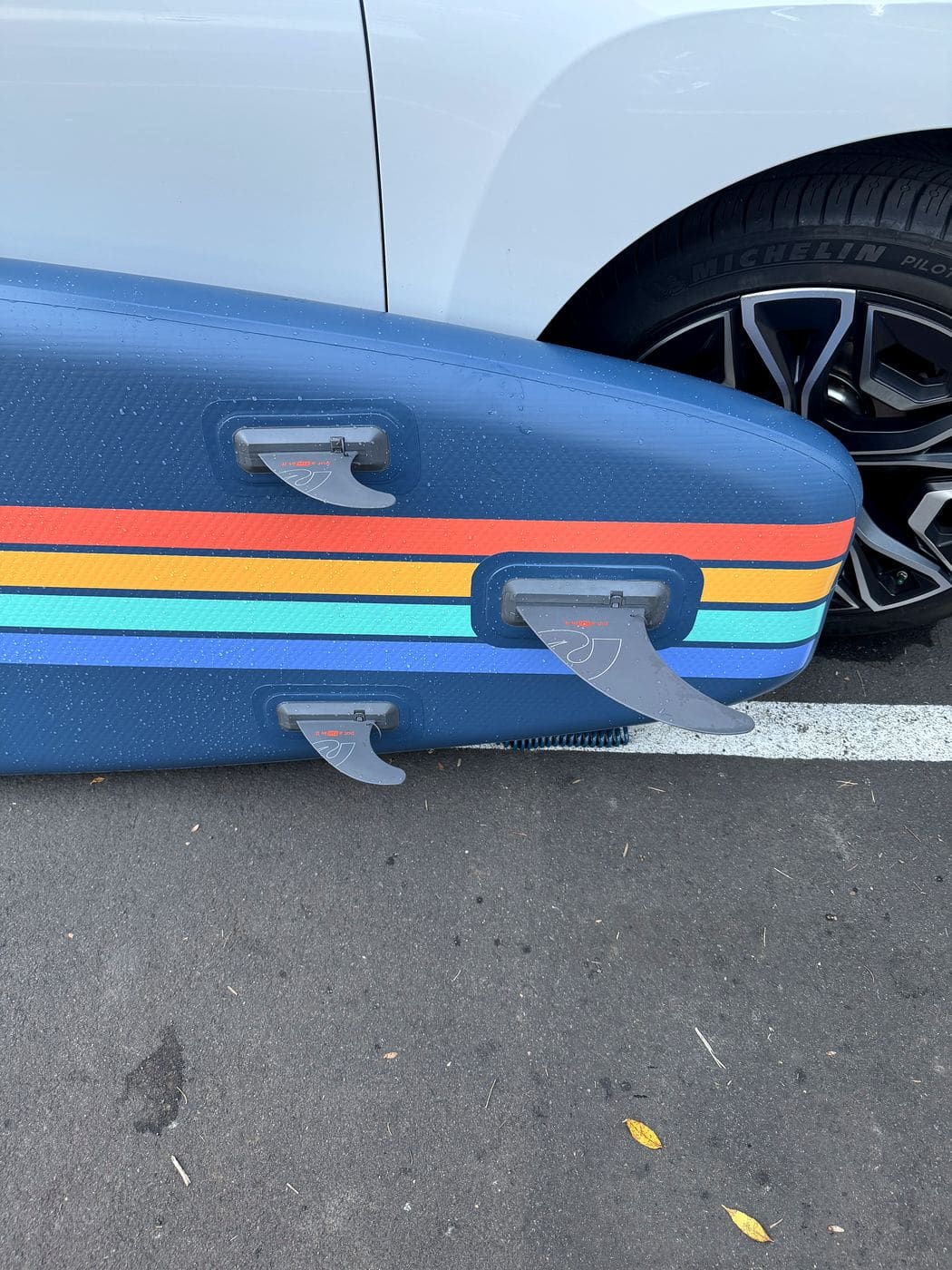 Three fins installed on the underside of the inflated Weekender with the rainbow stripes visible