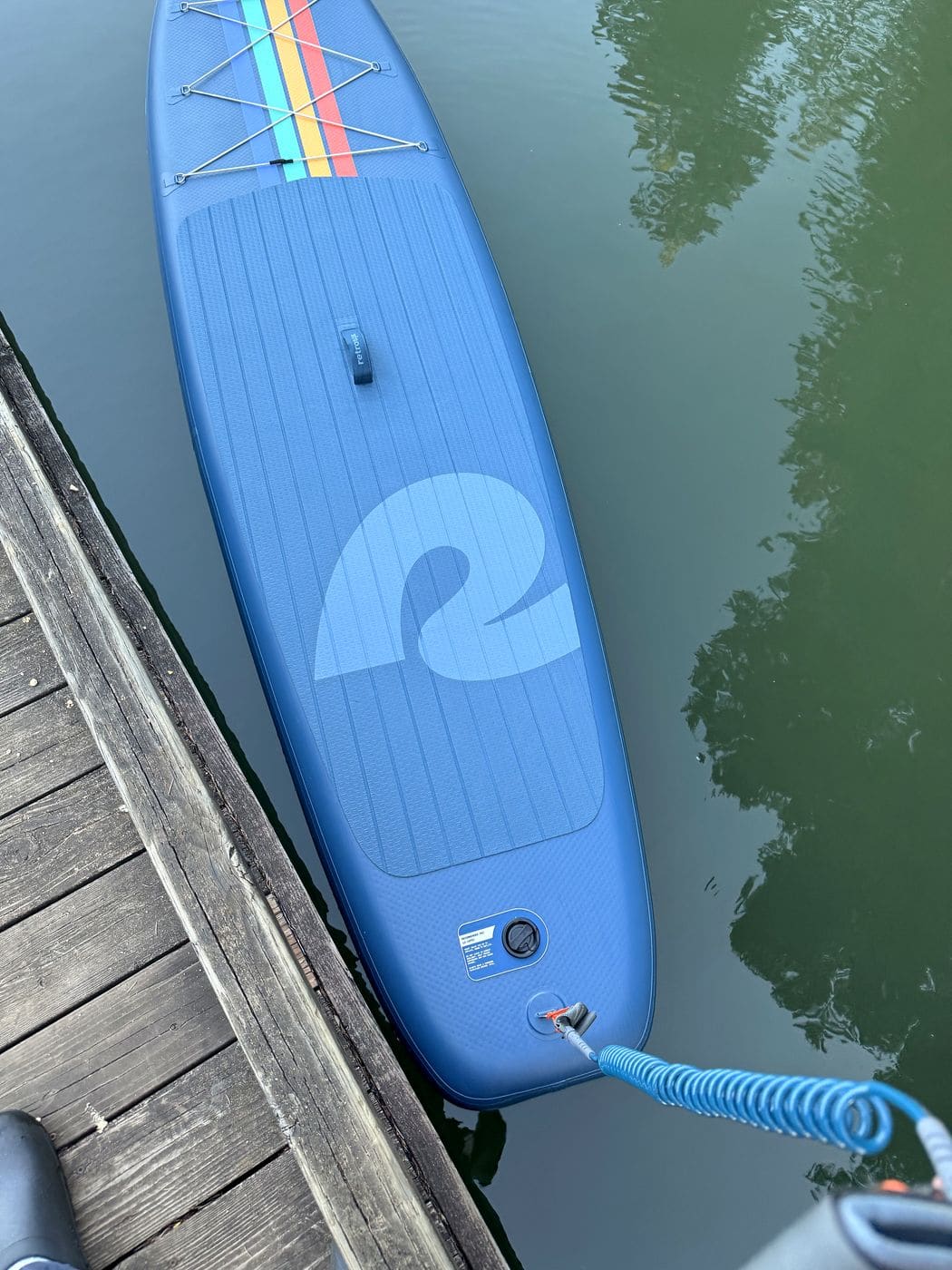 Fully inflated Weekender floating at the dock with the coiled leash attached at the tail