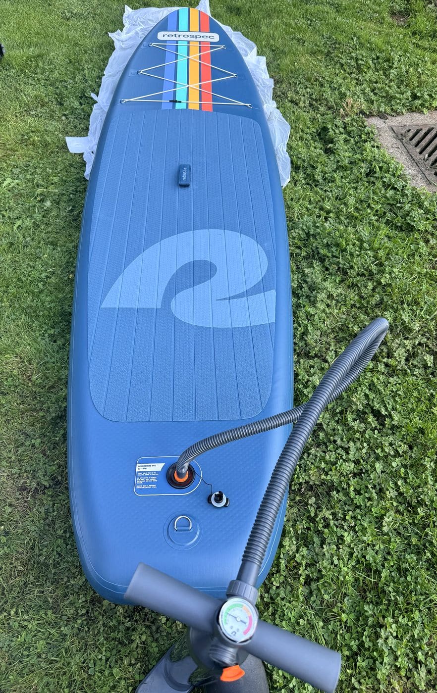 Weekender partially inflated on the grass with the pump hose connected at the tail valve