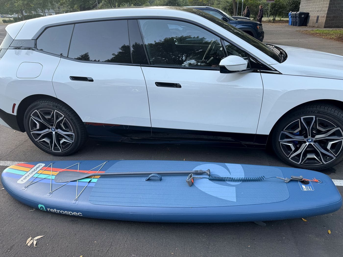 Inflated Weekender lying on the pavement beside a white SUV for size reference