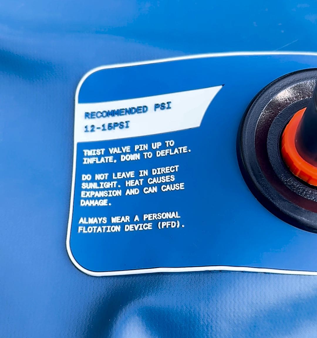 Close-up of the valve label on the Retrospec Weekender reading recommended PSI 12-15 PSI with instructions to twist the valve pin up to inflate