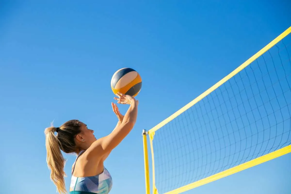 hitting a ball over net in beach volleyball